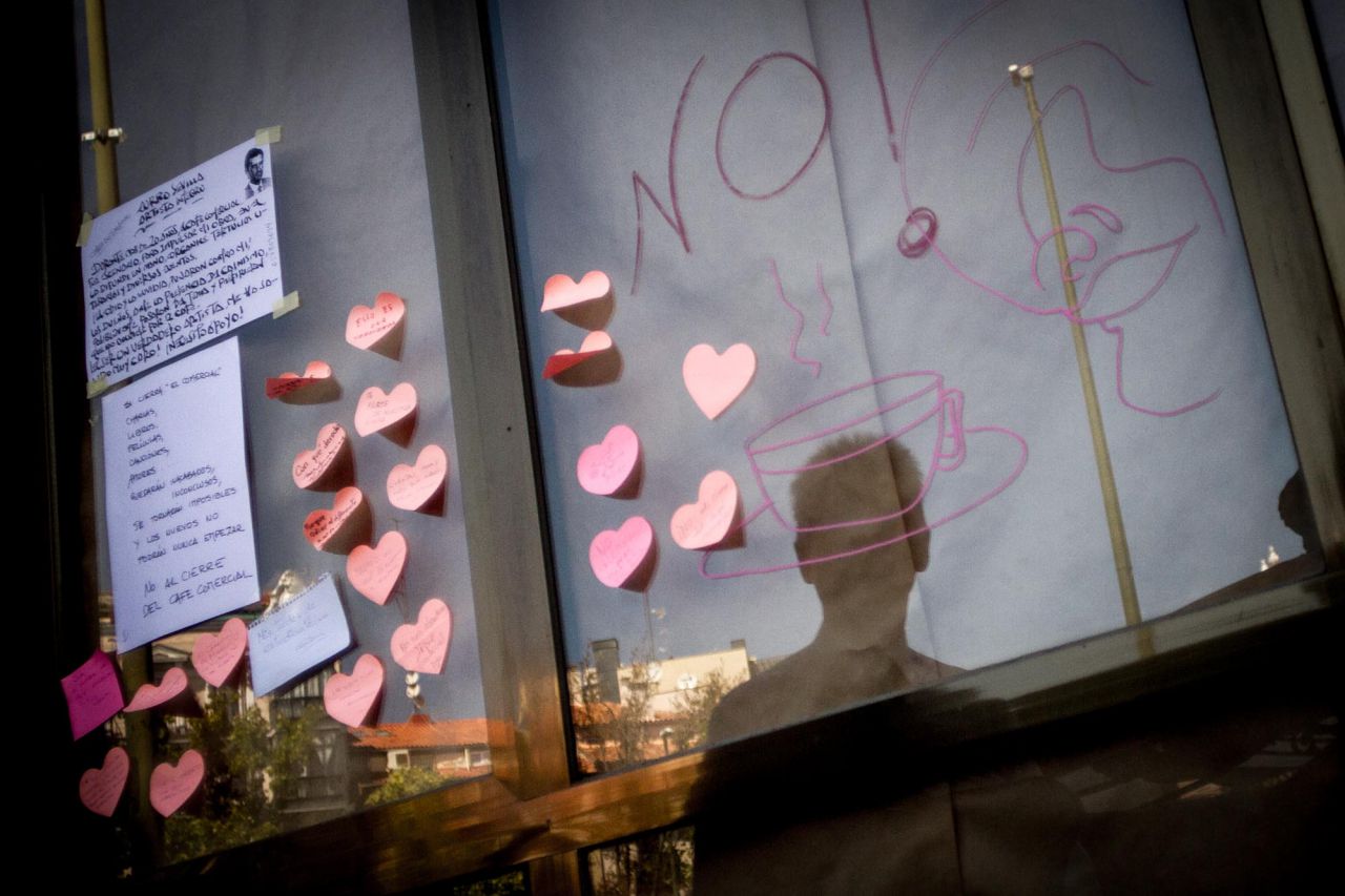 Reflejo de una persona en el escaparate del Café Comercial.