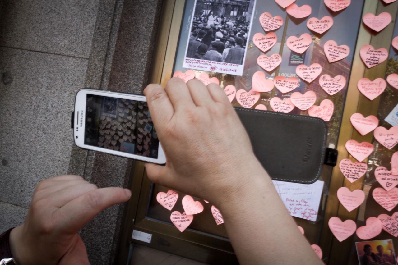 Muchas personas se acercan y hacen fotos a los recuerdos y reinvindicaciones pegados en los escaparates del Café Comercial.