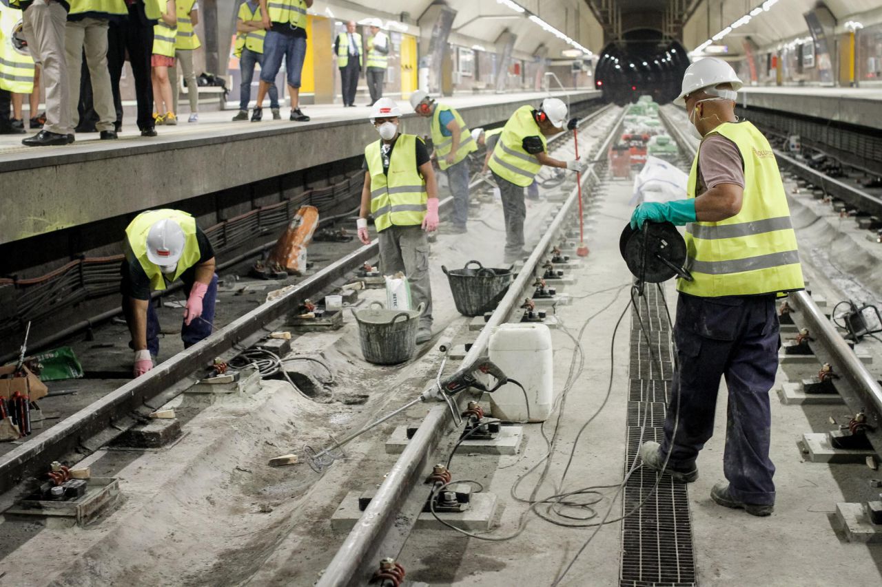 Trabajadores adecuan las vías de metro en la estación de metro de Carpetana.