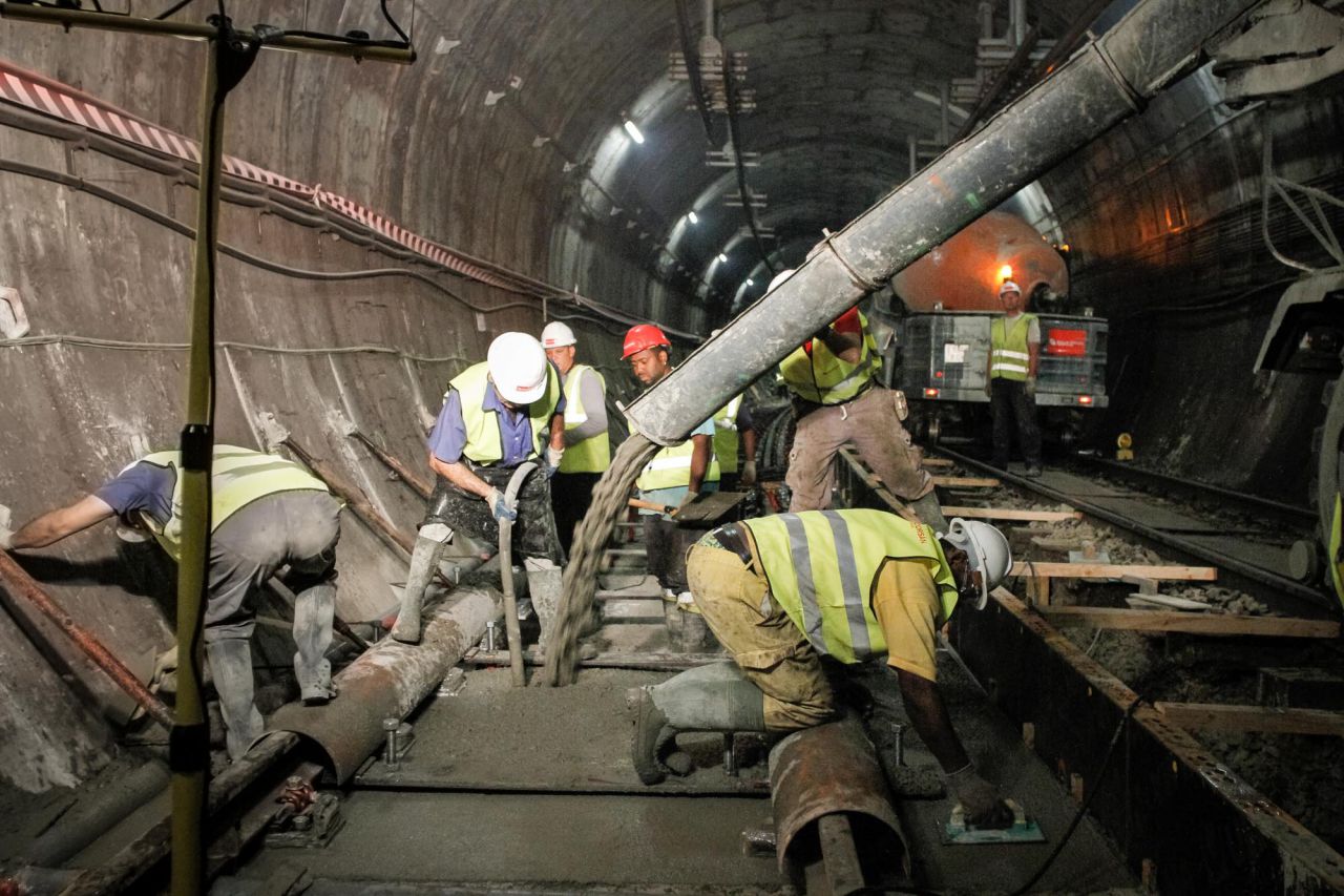 Un grupo de trabajadores hormigonan las vías del metro a su paso por la estación de Carpetana de la línea 6.