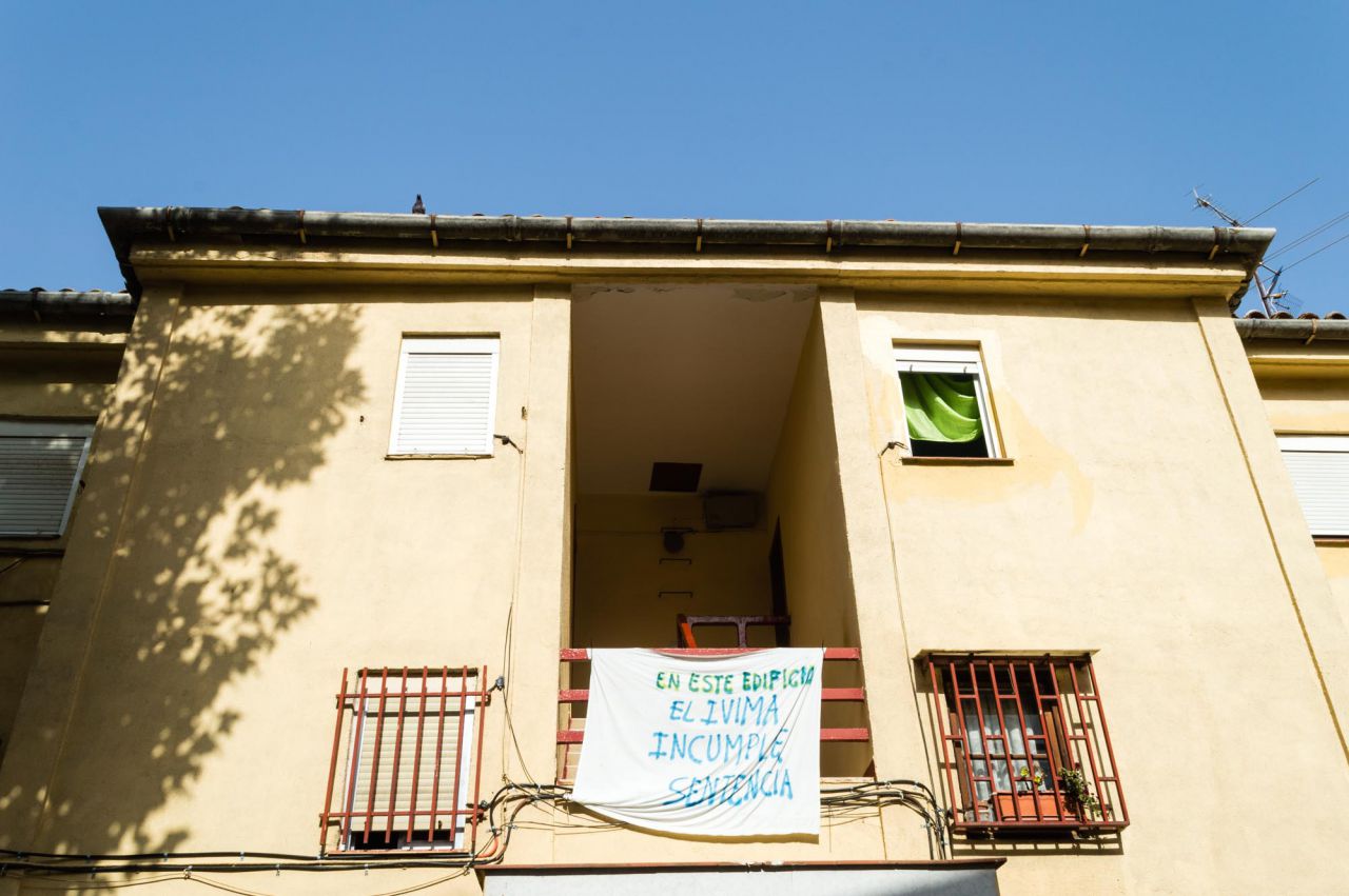 Detalle de una de las fachadas con pancarta de protesta de los vecinos.