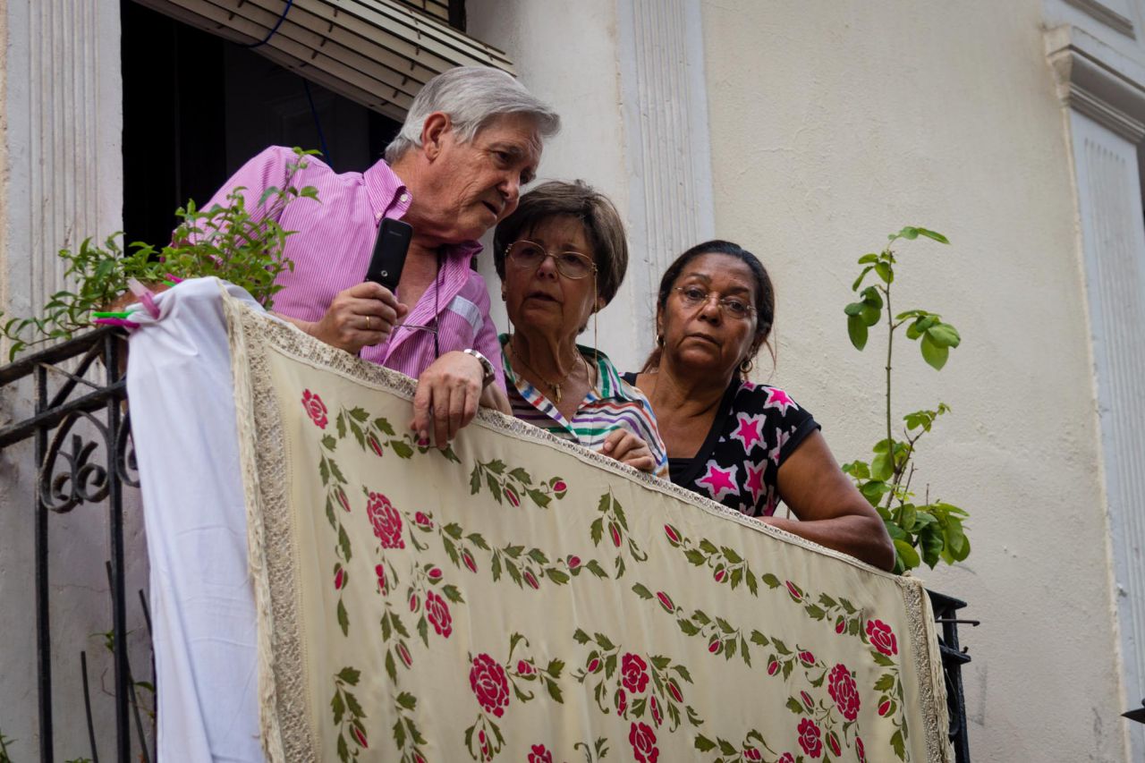 Vecinos observan desde sus balcones la procesión de San Lorenzo.