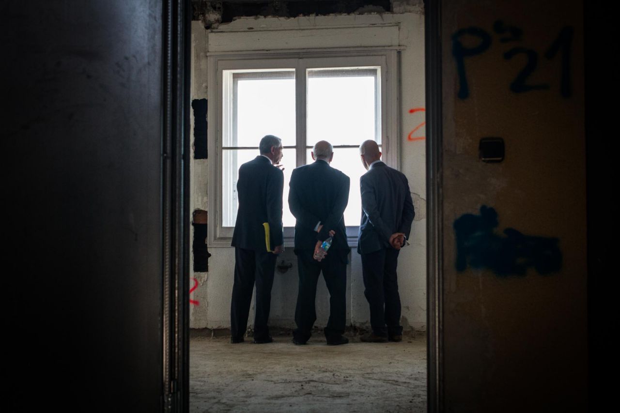 Varios técnicos contratados por la empresa Wanda miran por una de las ventanas de la planta 21 del edificio España.