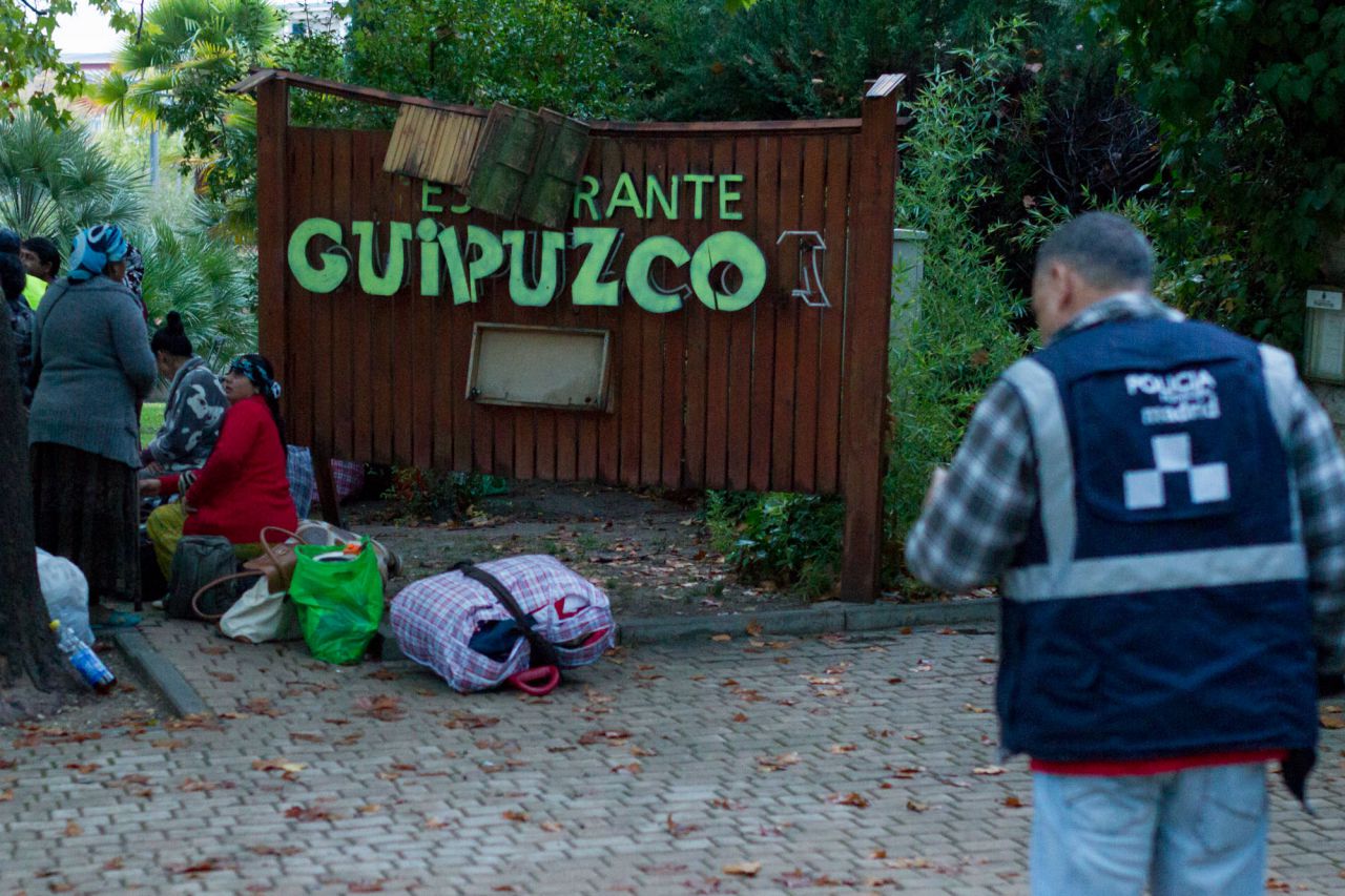 Varios ocupantes esperan a más furgonetas del Samur Social con sus enseres en la puerta del restaurante.