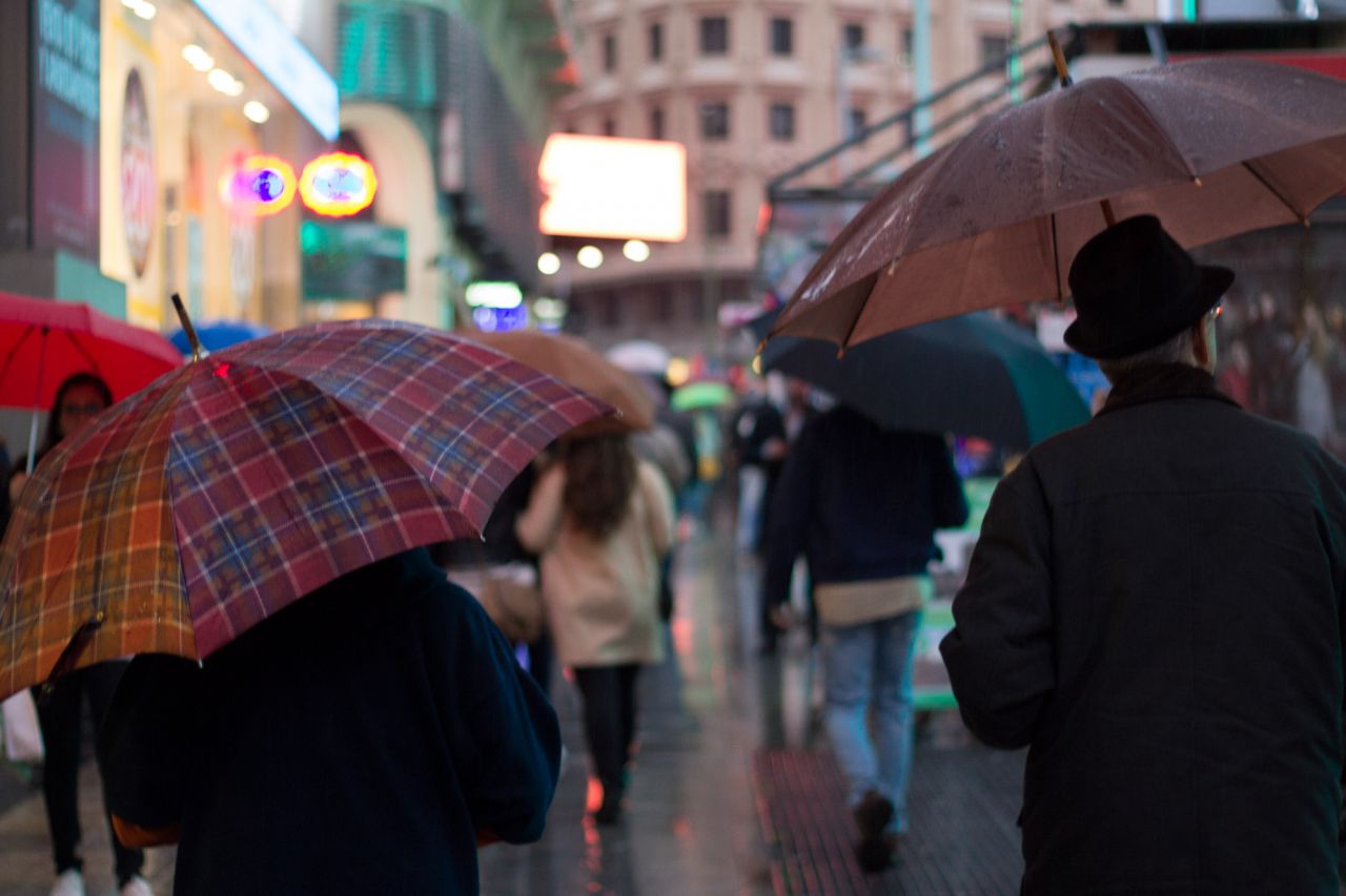 Paseantes bajo la lluvia en la Gran Vía de Madrid