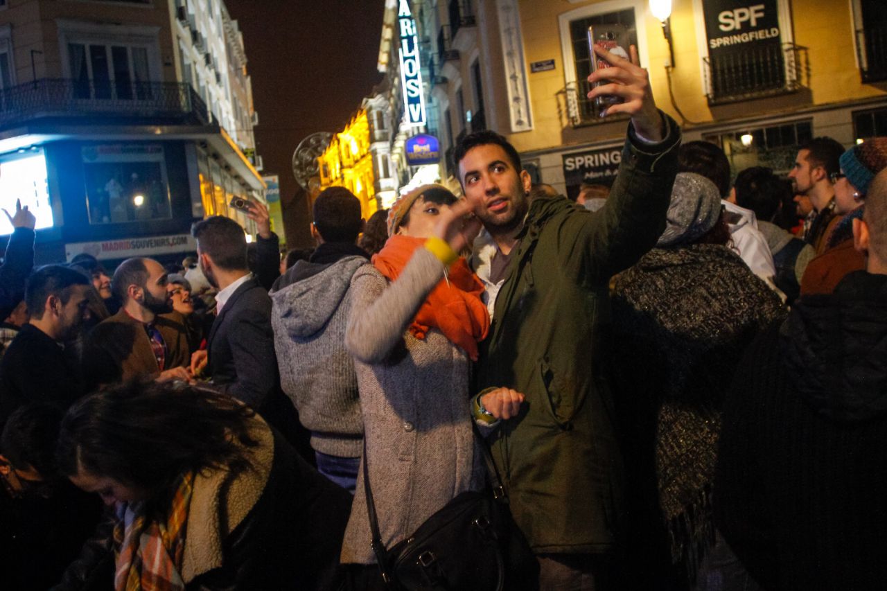 Una pareja se hace un selfie tras intuir las campanadas de la Puerta del Sol.