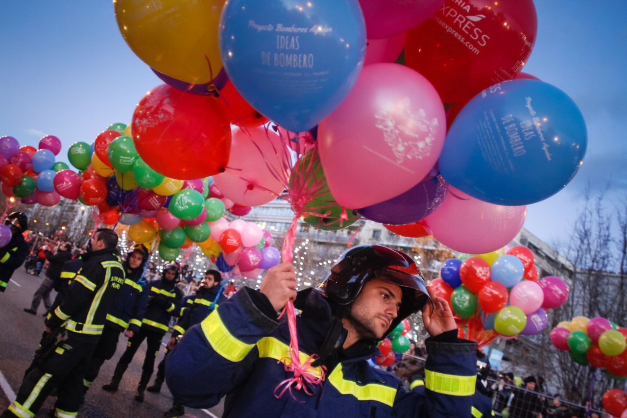 Un bombero del Ayuntamiento de Madrid se coloca el casco antes de empezar la cabalgata.