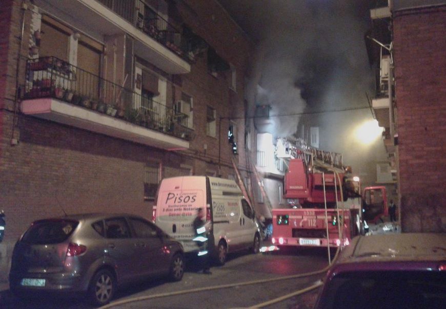 Los bomberos intentan apagar el fuego originado en el interior de la vivienda