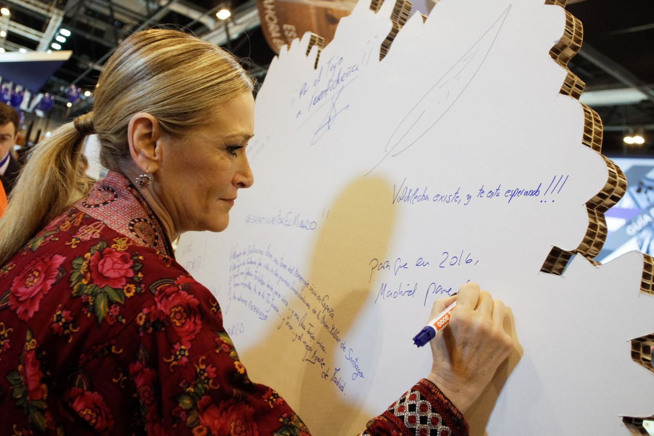 Cristina Cifuentes firma en uno de los apartados del stand e d eMadrid de Fitur.
