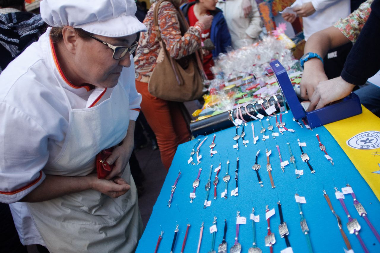 Una de las cocineras del comedor elige entre las pulseras realizadas por los alumnos.