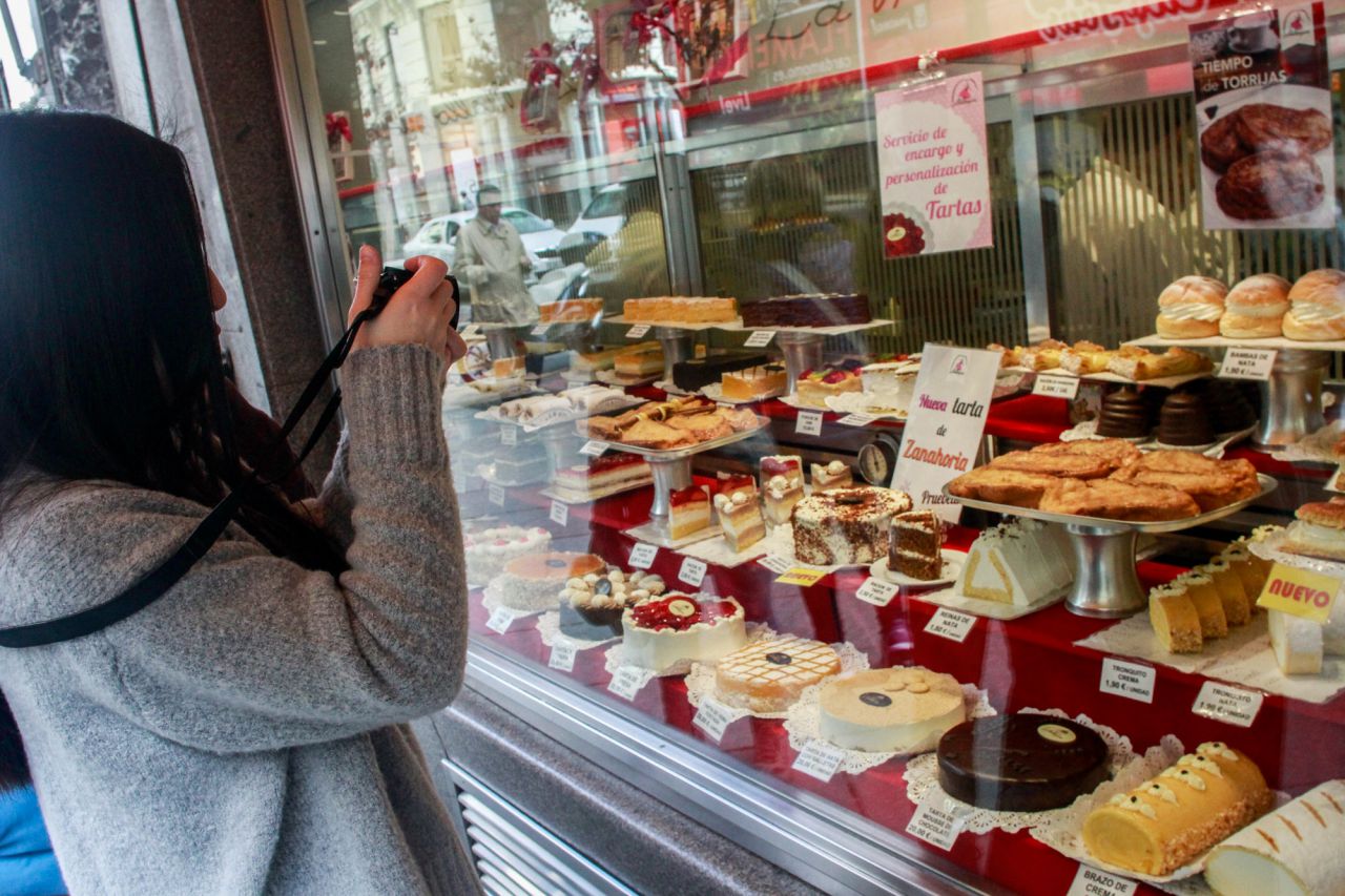 Una turista hace una foto a las torrijas en el escaparate de la Mallorquina.