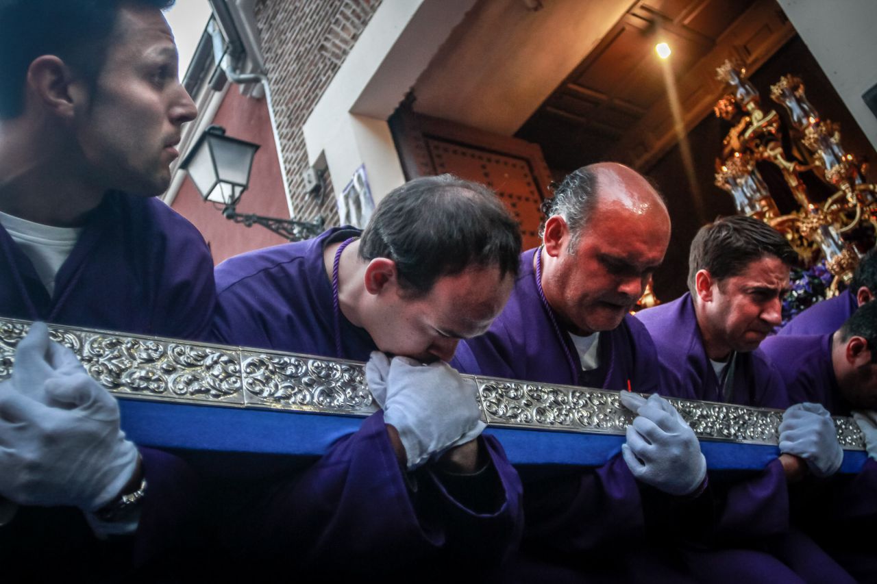 Los anderos de la cofradía de Jesús el Pobre maniobran en cuclillas con todo el peso de la talla para salvar el dintel de la puerta de la iglesia de San Pedro el Viejo.