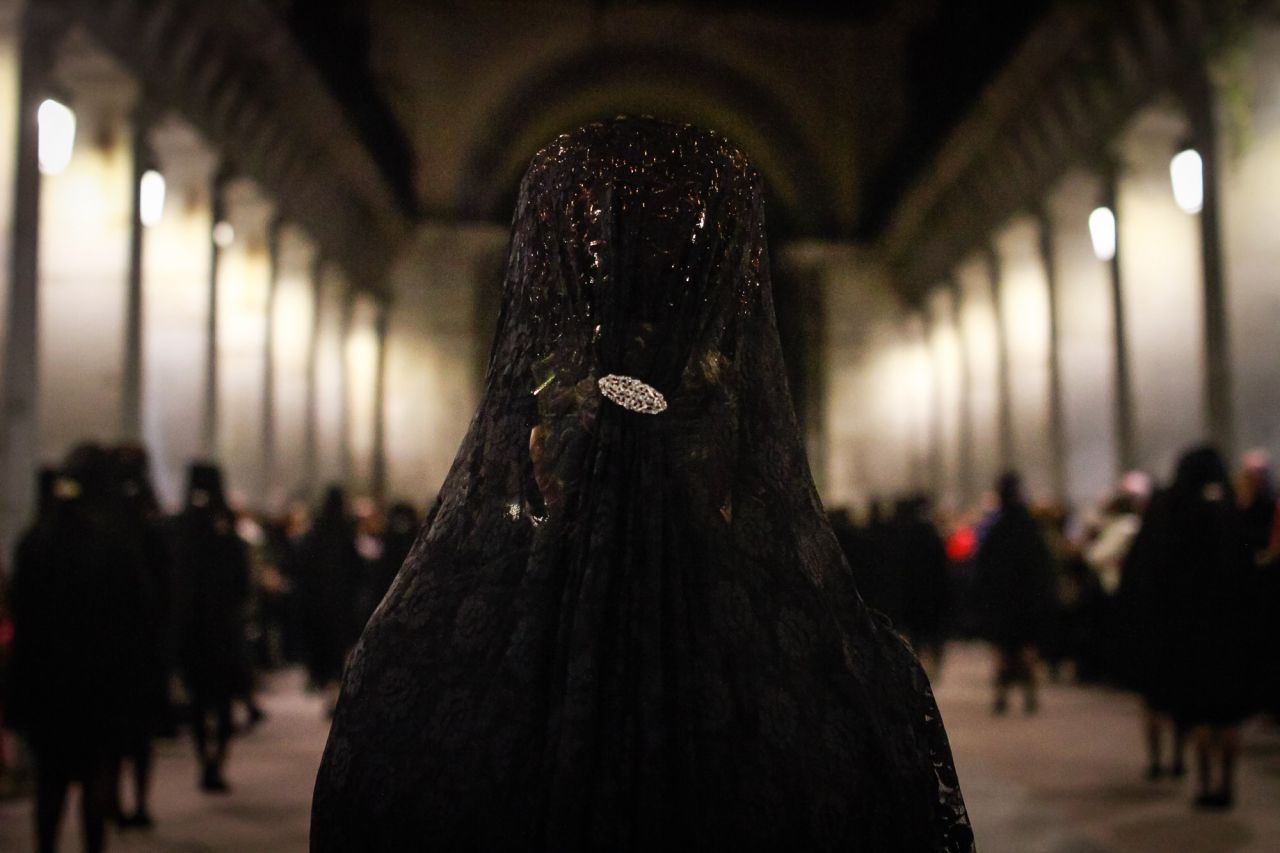 Mujeres con mantilla y peineta siguen a la imágen de Nuestro Padre Jesús el Pobre.