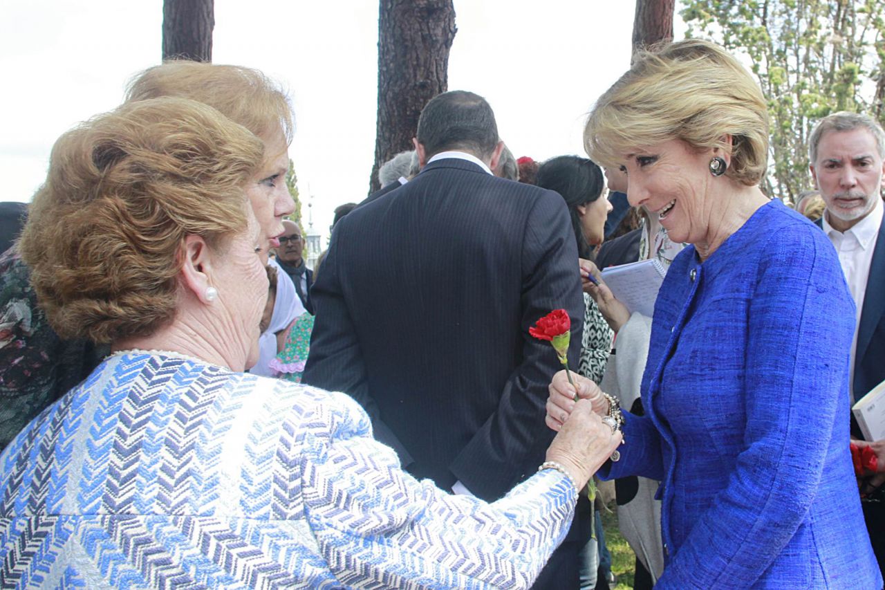 Una señora le regala un clavel a Esperanza Aguirre.