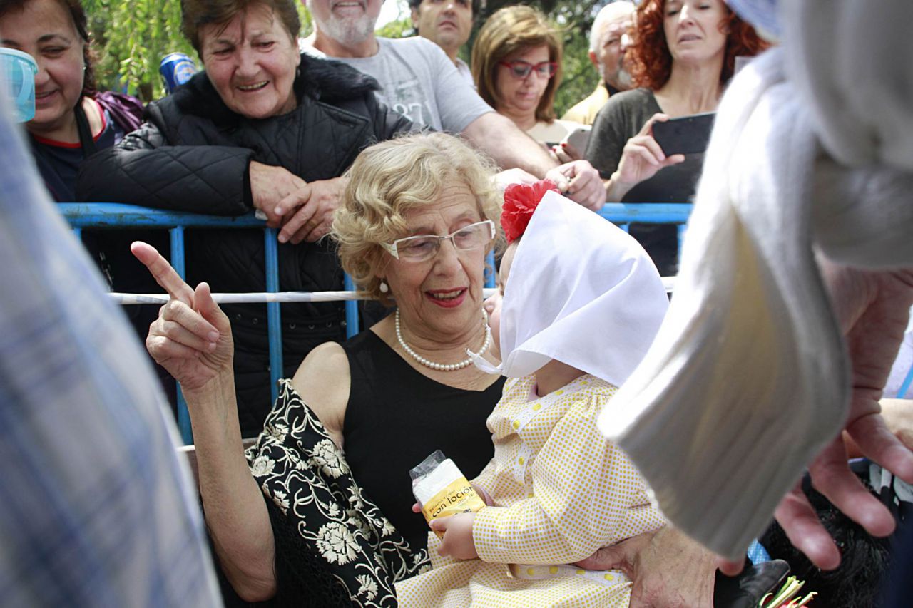 Manuela Carmena sujeta un bebé vestido de chulapo.