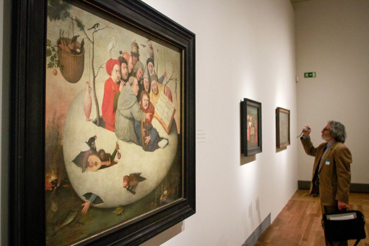 Un colorido grupo de cantantes y músicos, dirigido por un fraile, surge de la cáscara de un  huevo.