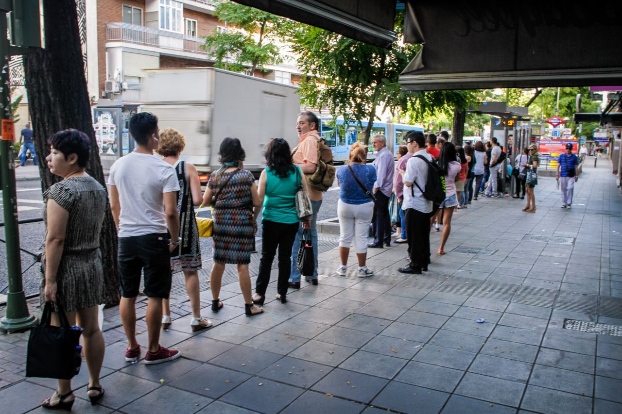 Cola de pasajeros que esperan al autobús de servicio especial entre Sierra de Guadalupe y Atocha en una parada en la avenida de la Albufera.