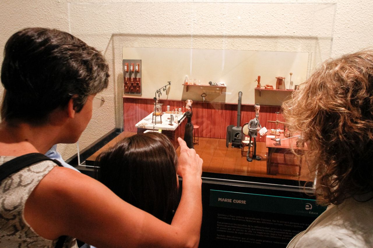 Una familia observa a los Curie en su laboratorio.