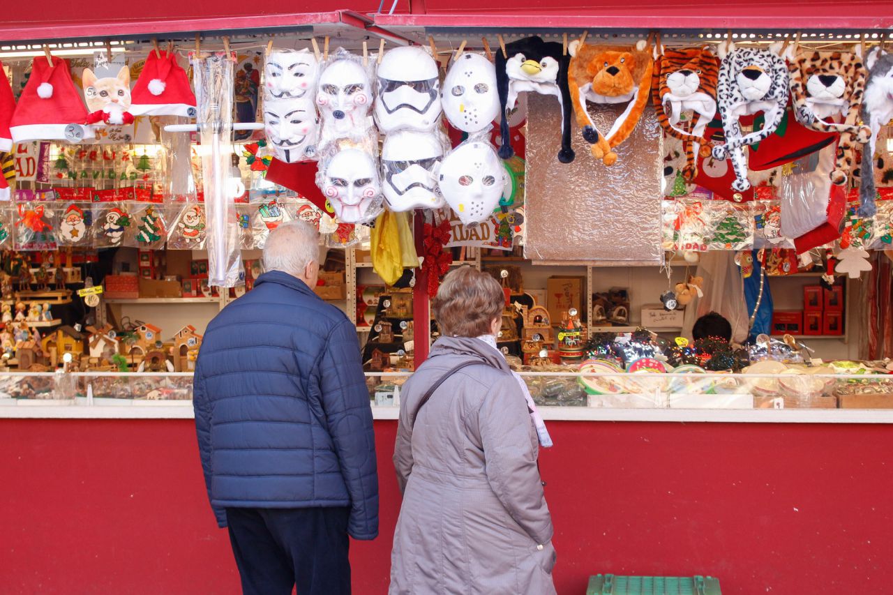 Dos personas mirando en un puesto del mercadillo navideño de la Plaza Mayor