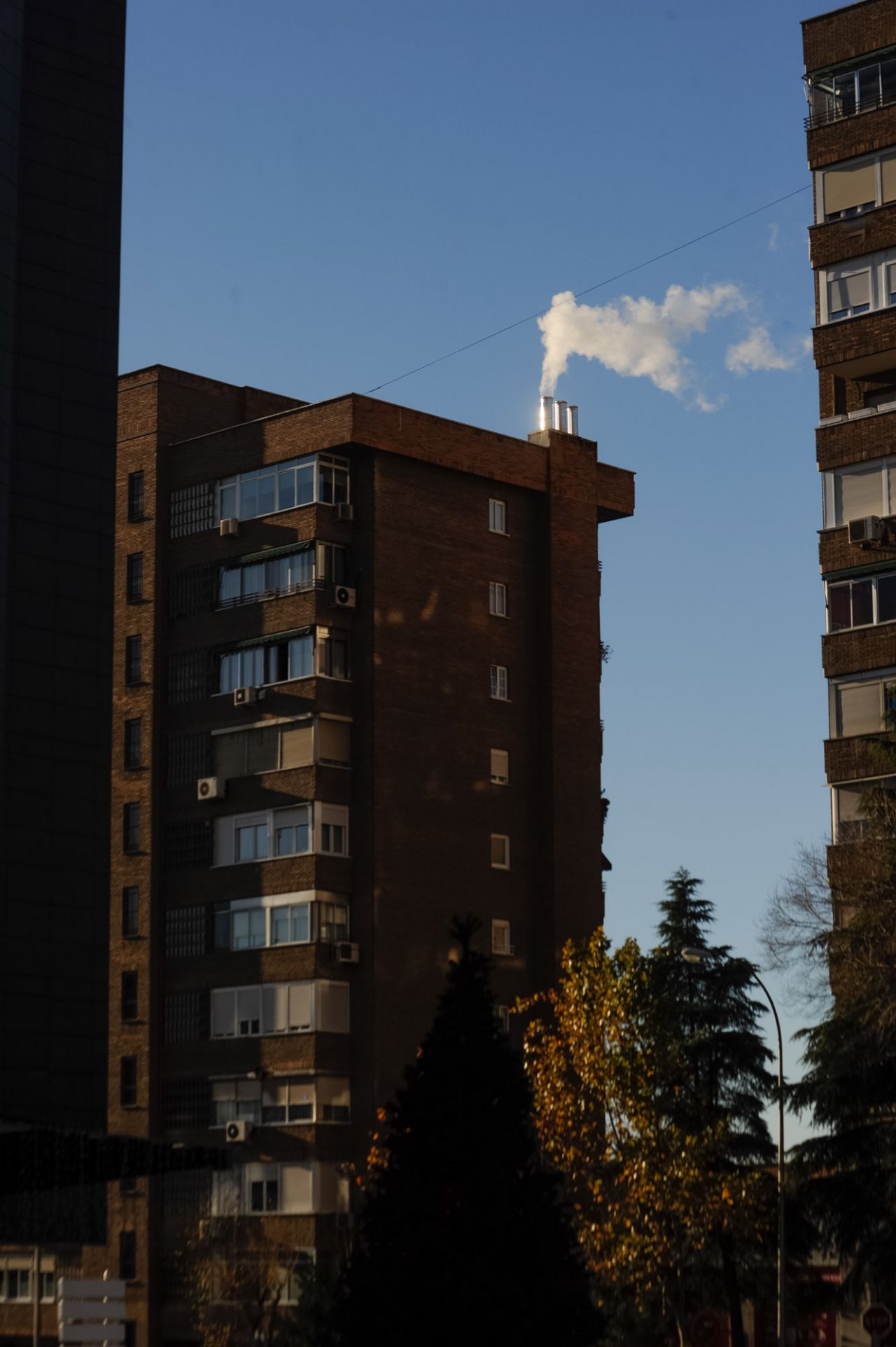 Humo de una chimenea de calefacción en un edificio en Conde de Casal.