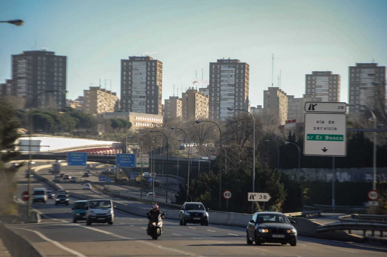 Entrada a Conde Casal por la A3, al fondo edificios con chimeneas y humo de calefacción.