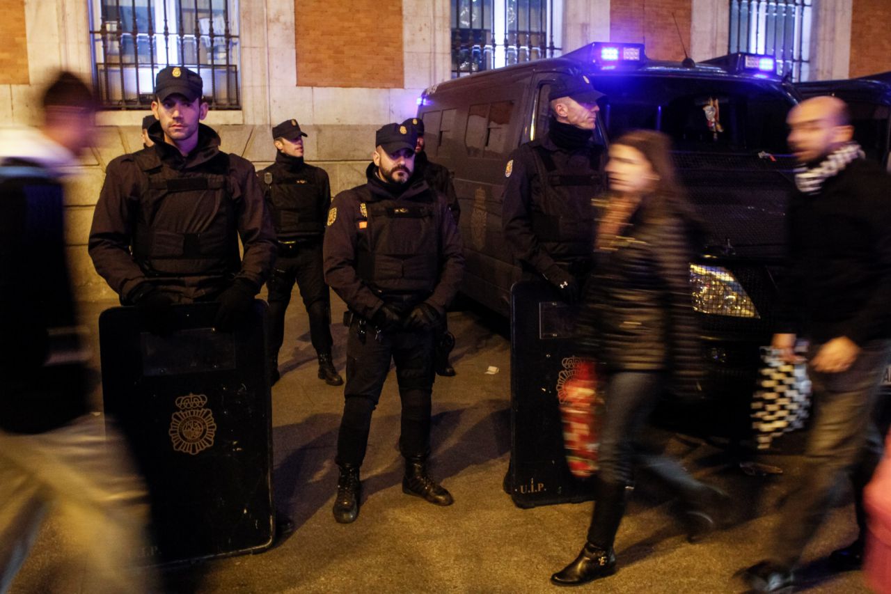 Varios agentes de la UIP de la Policía Nacional vigilan armados con armas de repetición y escudos balísticos la Puerta del Sol.