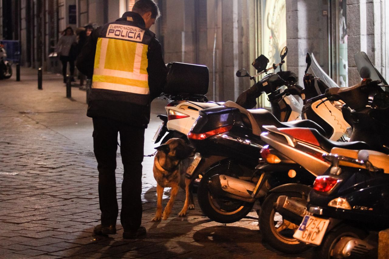 Un agente de la unidad de policía canera inspecciona varias motocicletas en la calle Espoz y Mina.