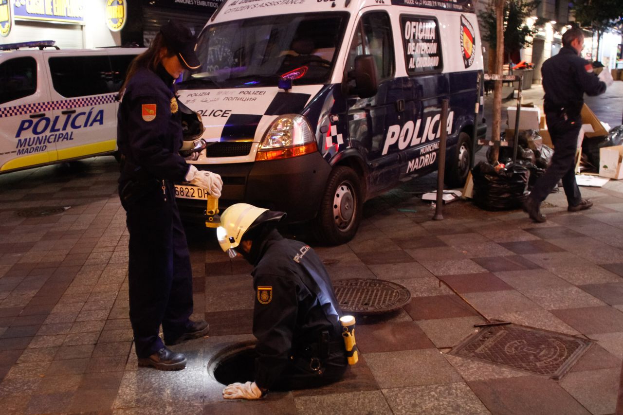 Agentes de la unidad de Subsuelo inspeccionan un alcantarilla al inicio de la calle Montera.