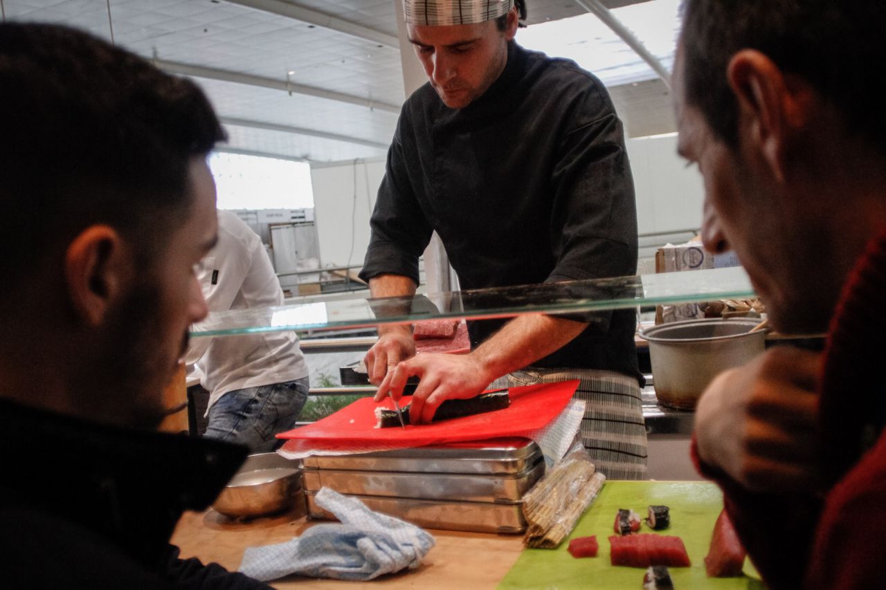 Asistentes observan la elaboración de sushi.