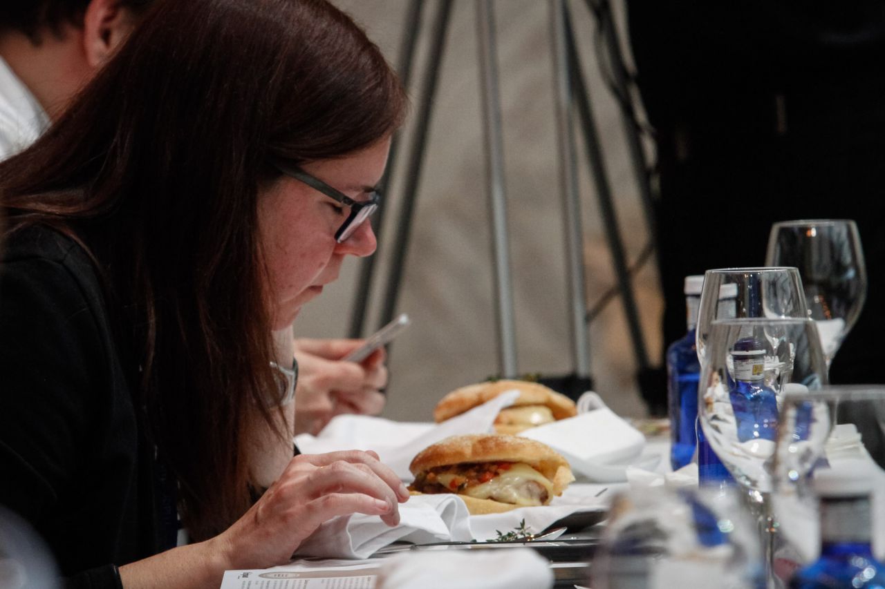 Una miembro del jurado huele una de las hamburguesas.