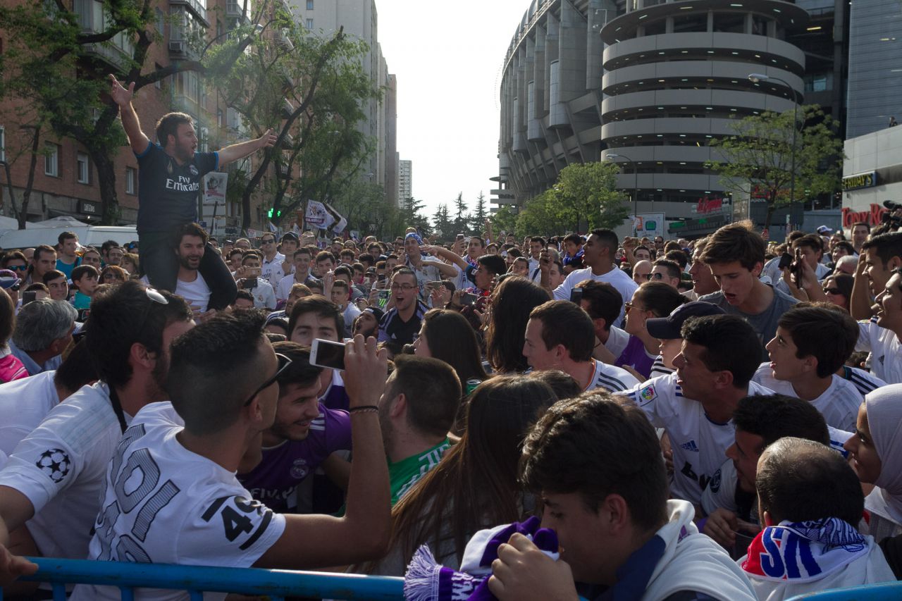 Aficionados del Real Madrid aguardan la llegada del autobús del equipo.