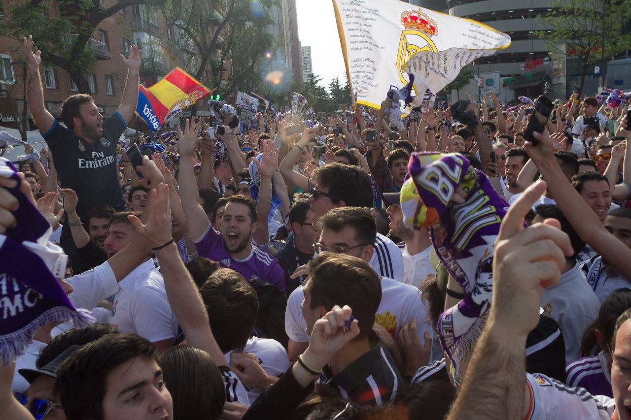 Aficionados del Real Madrid aguardan la llegada del autobús del equipo.