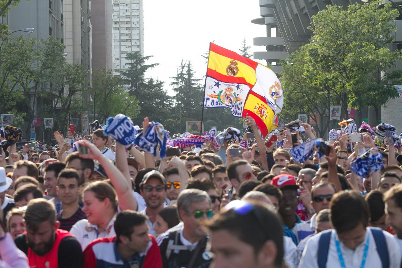 Aficionados del Real Madrid aguardan la llegada del autobús del equipo.