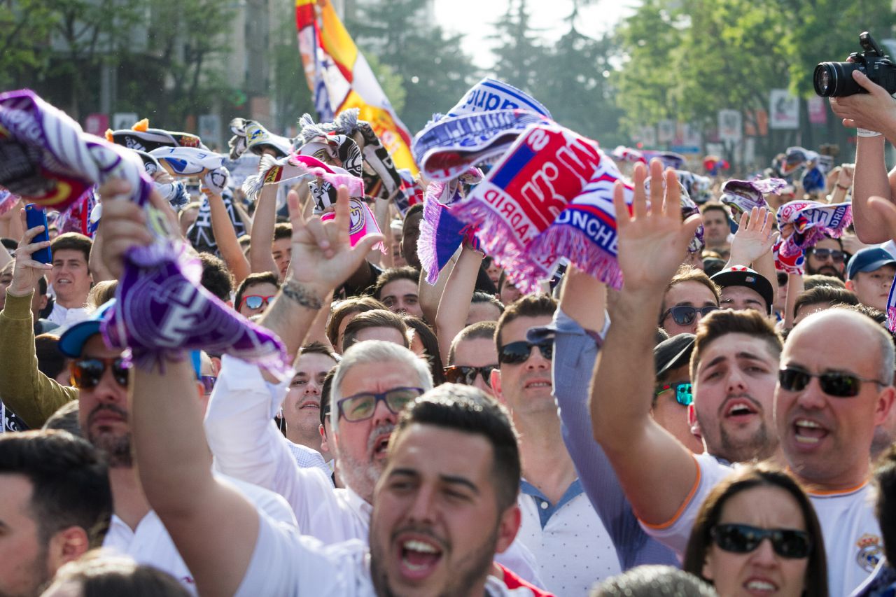 Aficionados del Real Madrid aguardan la llegada del autobús del equipo.