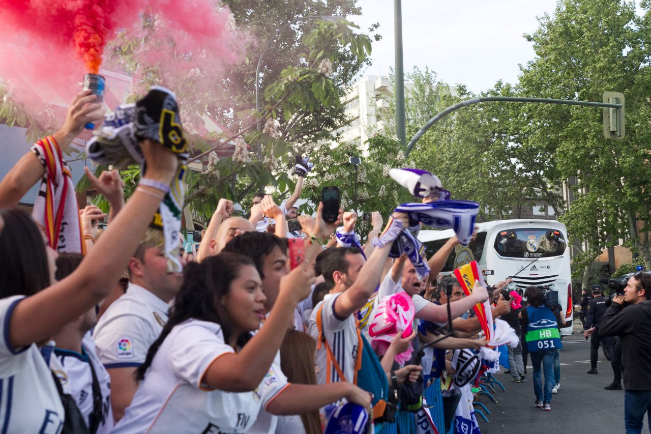 Aficionados del Real Madrid aguardan la llegada del autobús del equipo.