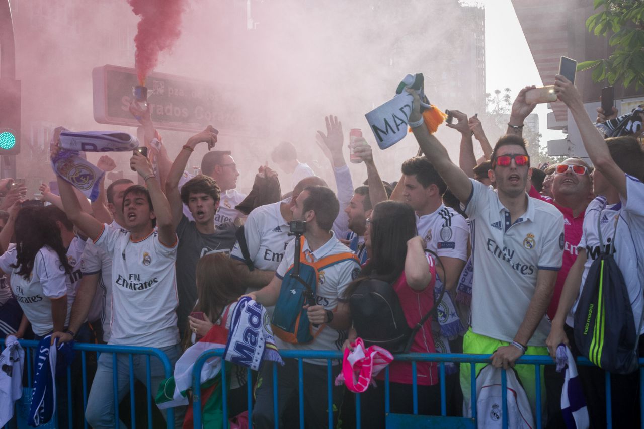 Aficionados del Real Madrid aguardan la llegada del autobús del equipo.