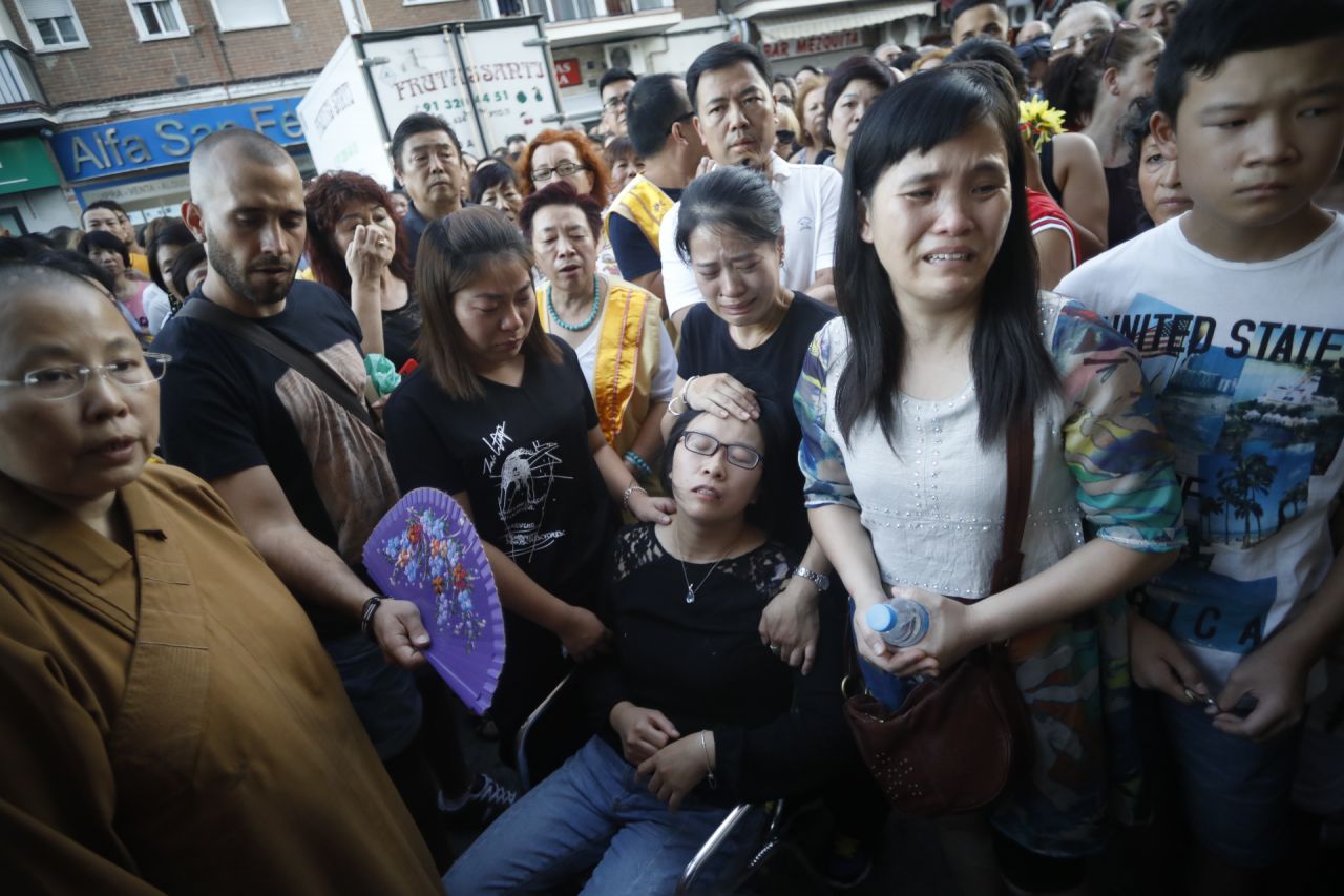 Varias personas ayudan a la madre de Ichi tras desmayarse por el dolor.