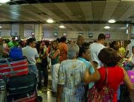 Largas colas de pasajeros en Barajas en el segundo día de la operación salida