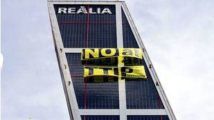 Greenpeace protesta contra el TTIP con una gran pancarta en las torres Kio