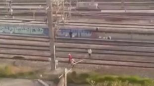 Un grupo de jóvenes cruza las vías del tren de Atocha por un paso no habilitado