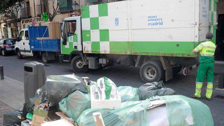 Camion de la basura y operarios recogen monton generado de basura