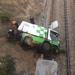 Dos heridos graves tras caerse un camión de Medio Ambiente a las vías del tren