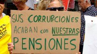 Una mujer participa con una pancarta en las marchas por las pensiones públicas que confluyen este lunes en Madrid