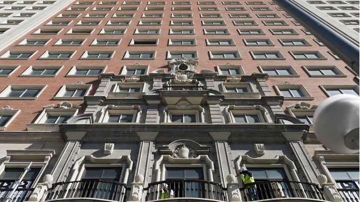 Operarios haciendo agujeros en las terazas del primer piso para fijar los andamios a la fachada.