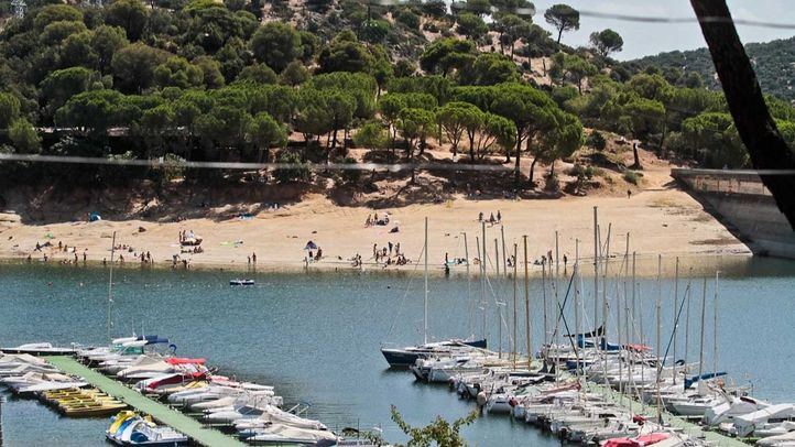 El embarcadero del pantano de San Juan con cientos de embarcaciones y la playa al lado de la presa.