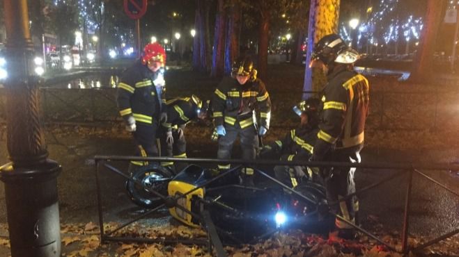 Los bomberos junto a la moto implicada en el accidente