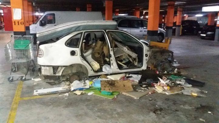 Coche destrozado en el garaje del edificio de viviendas públicas del Ensanche de Vallecas