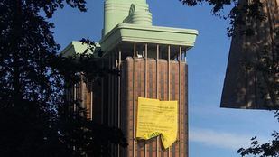 Cuatro escaladores de la organización ecologista han trepado por la fachada de las torres de Colón donde han desplegado una pancarta de cerca de 300 metros cuadrados.