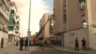 Bomberos, en el lugar del desahucio, convenciendo a la mujer para que regrese al interior del domicilio.