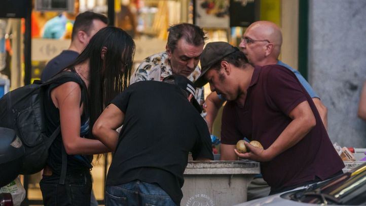 Personas necesitadas buscan comida en los cubos de basura de un centro comercial.